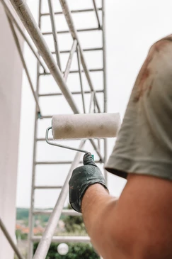 Un constructeur est debout dans une maison dans un processus de rénovation et de mélange de plâtre pour rénover et peindre les murs de revêtement